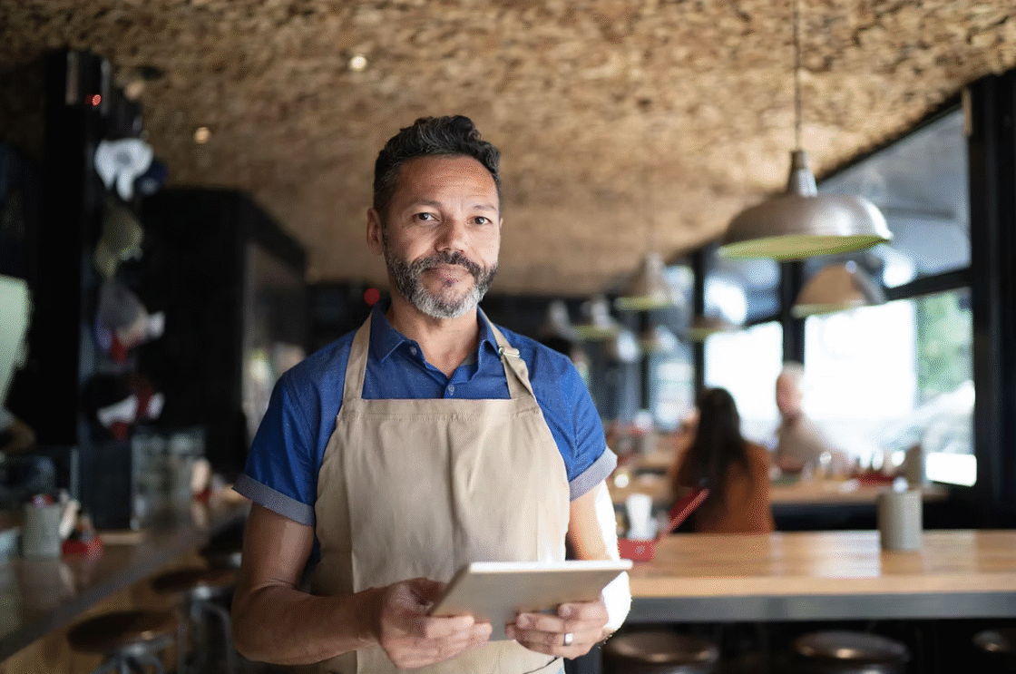 Restaurant host standing with an iPad.